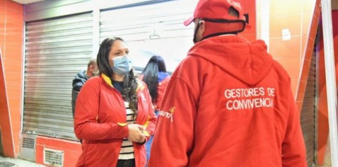 alcaldesa local y policía con tapabocas 